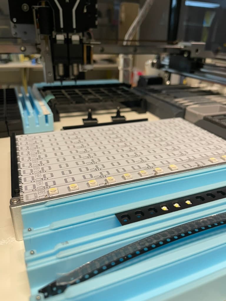 A panel of freshly manufactured GridLights LED PCBs in a pick-and-place machine.